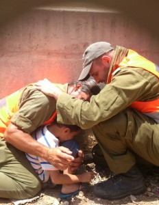 IDF officers shield a 4-year-old boy, protecting him with their own bodies during a Hamas rocket attack, July 15, 2014 © Li Aviv Dadon | Flickr