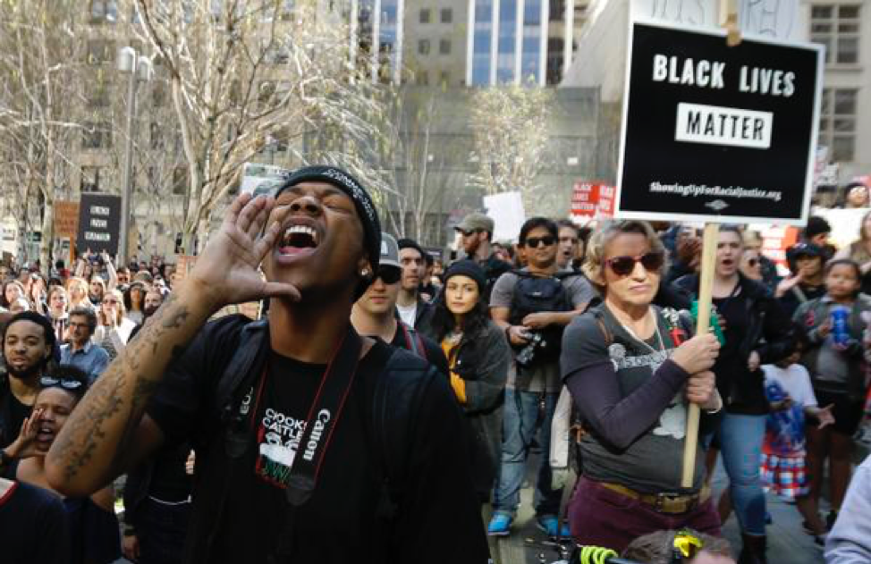 A group of people standing in front of a crowd posing for the camera

Description automatically generated