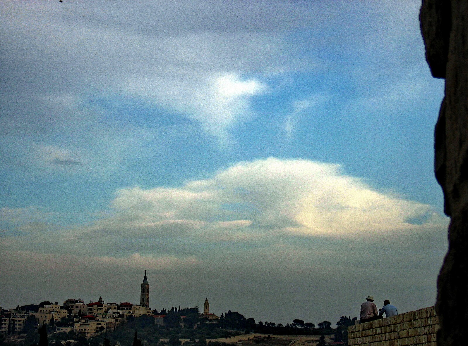 Two figures silhouetted against Jerusalem skyline