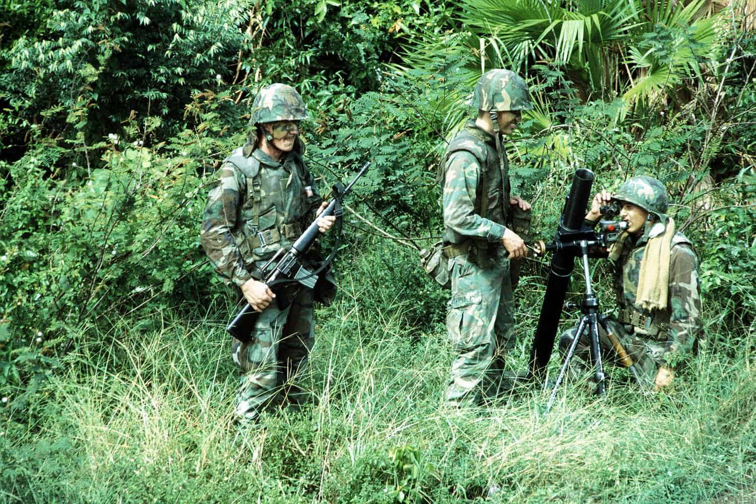 Soldiers prepare to fire an 81 mm mortar during the joint US/Honduras field training Exercise AHUAS TARA II (BIG PINE). The soldier at the right is armed with an M16A1 rifle.