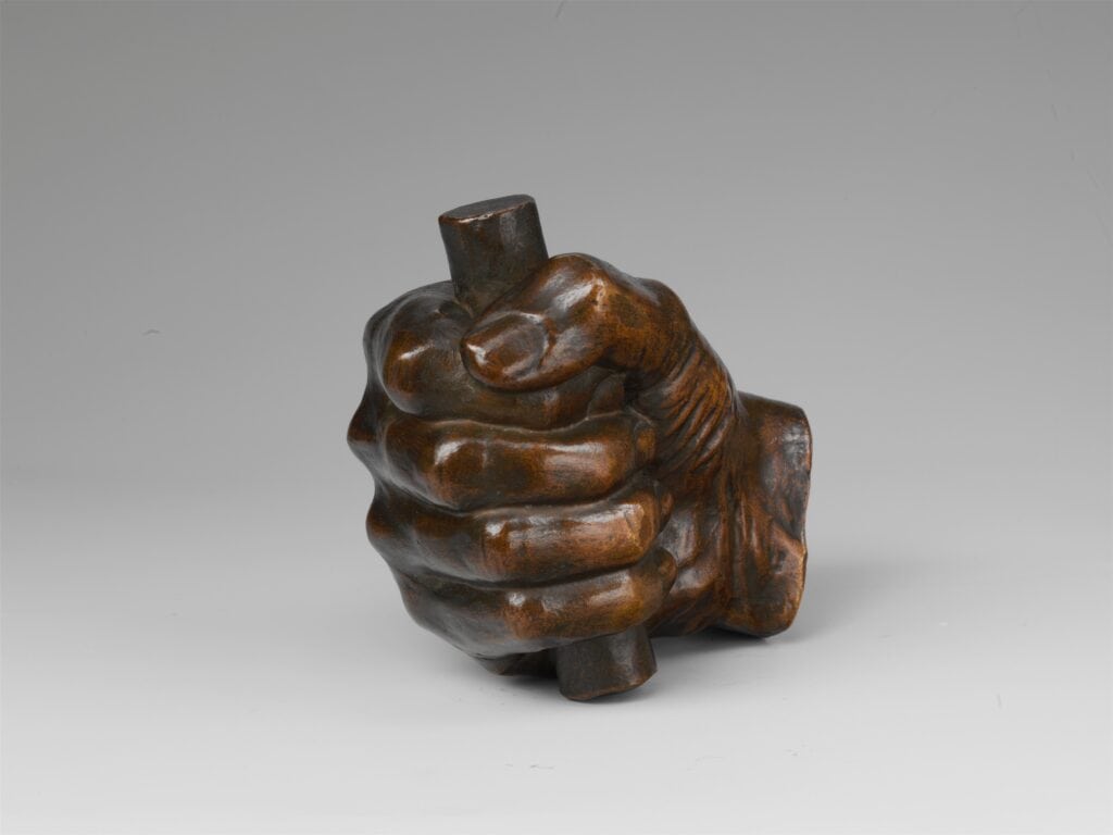 Photograph of a bronze mold of Abraham Lincoln's hand grasping a wooden stick.