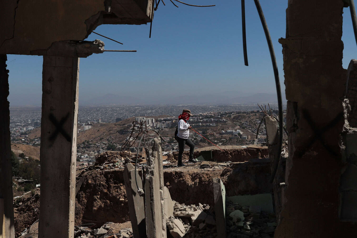 A person walking around rubble to search for disappeared persons