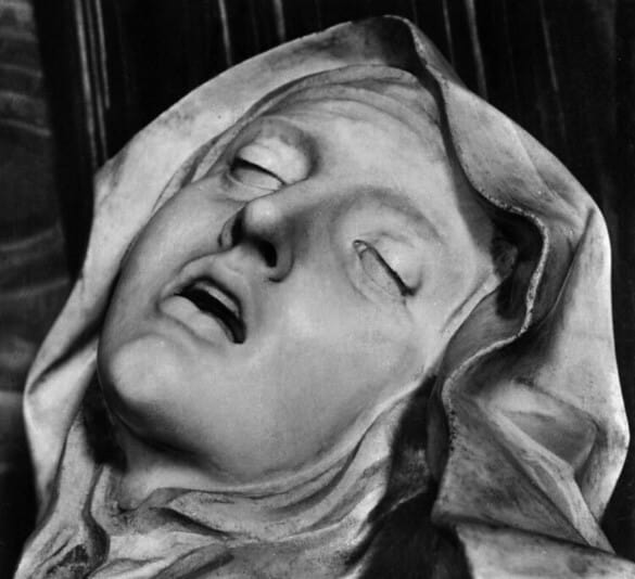 Detail of marble sculpture of woman in veil with eyes closed and mouth open in expression of ecstasy