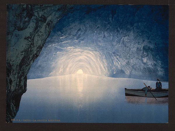 A drawing of an icy blue grotto with two figures in a boat at the far right and an opening in the back wall emitting brilliant white light over the scene.