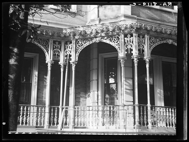 Black and white image of an ornate cast ironwork porch facade of a home in Mobile, Alabama