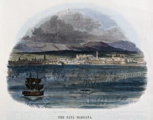 A wood engraving showing a reflection of the city of Messina in the surrounding water with a ship in the foreground and mountains in the background. Text underneath the image reads “the fata morgana.”